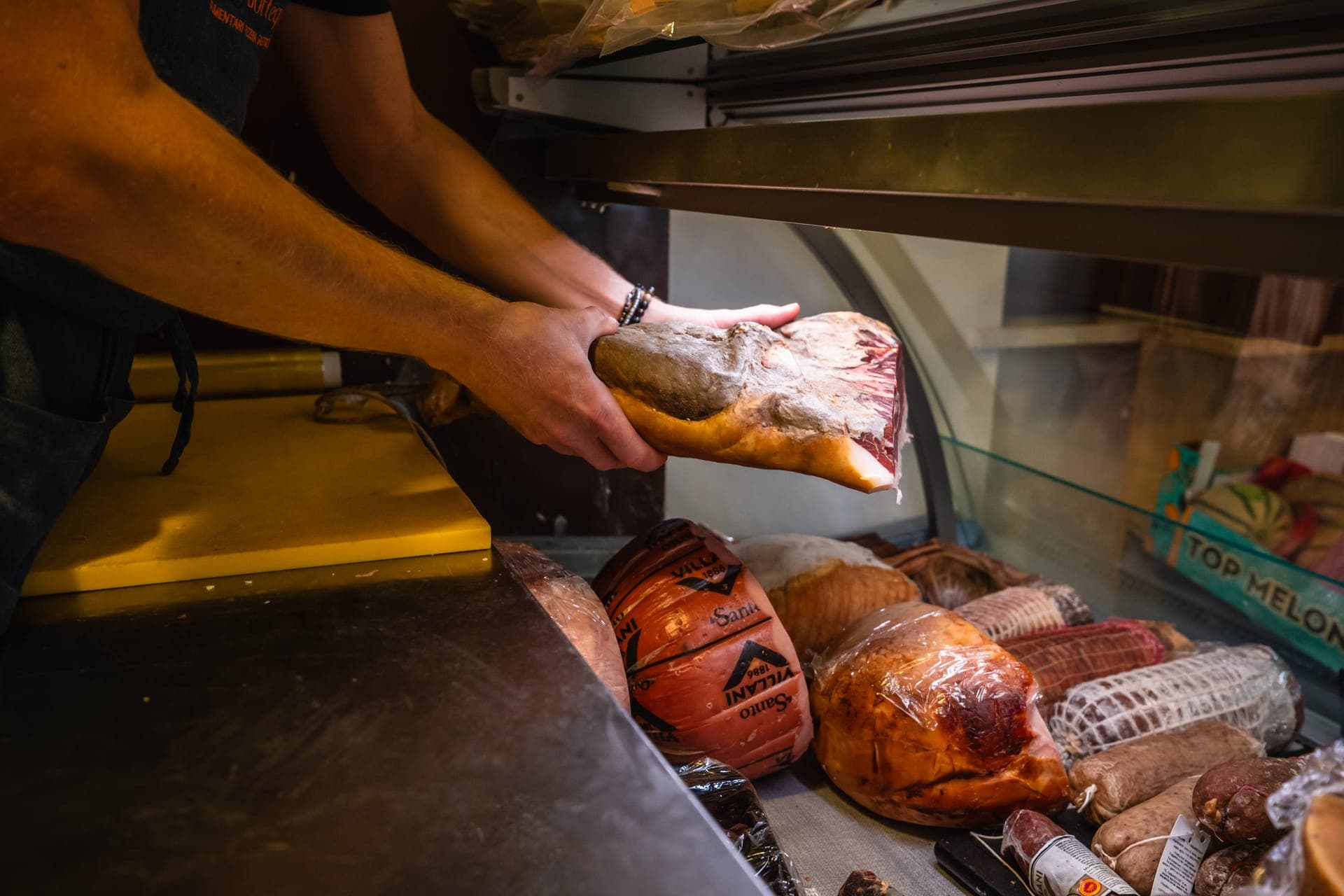 Preparazione del prosciutto al banco della Bottega di Roberto Bolletta